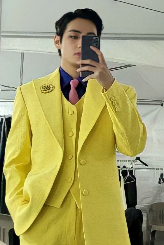 Kpop idol V from BTS in a statement bold yellow jacket