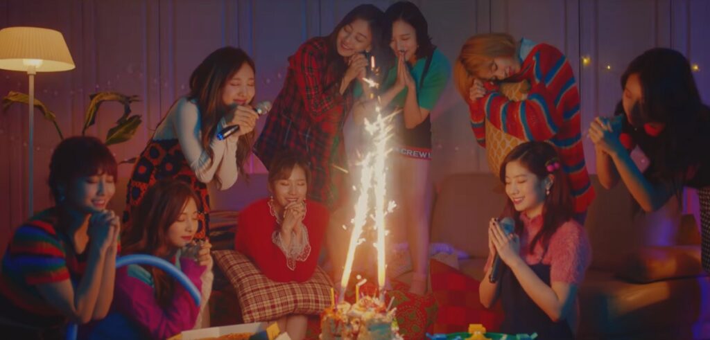 Girl group Twice in kpop christmas song merry & happy, sitting around a cake